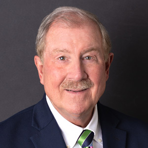 Bill Montgomery, Chairman, President and CEO, smiles in front of a black background.