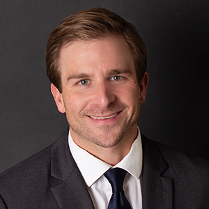 Scott Montgomery, Vice President of Distribution & Corporate Secretary, smiles in front of a black background.