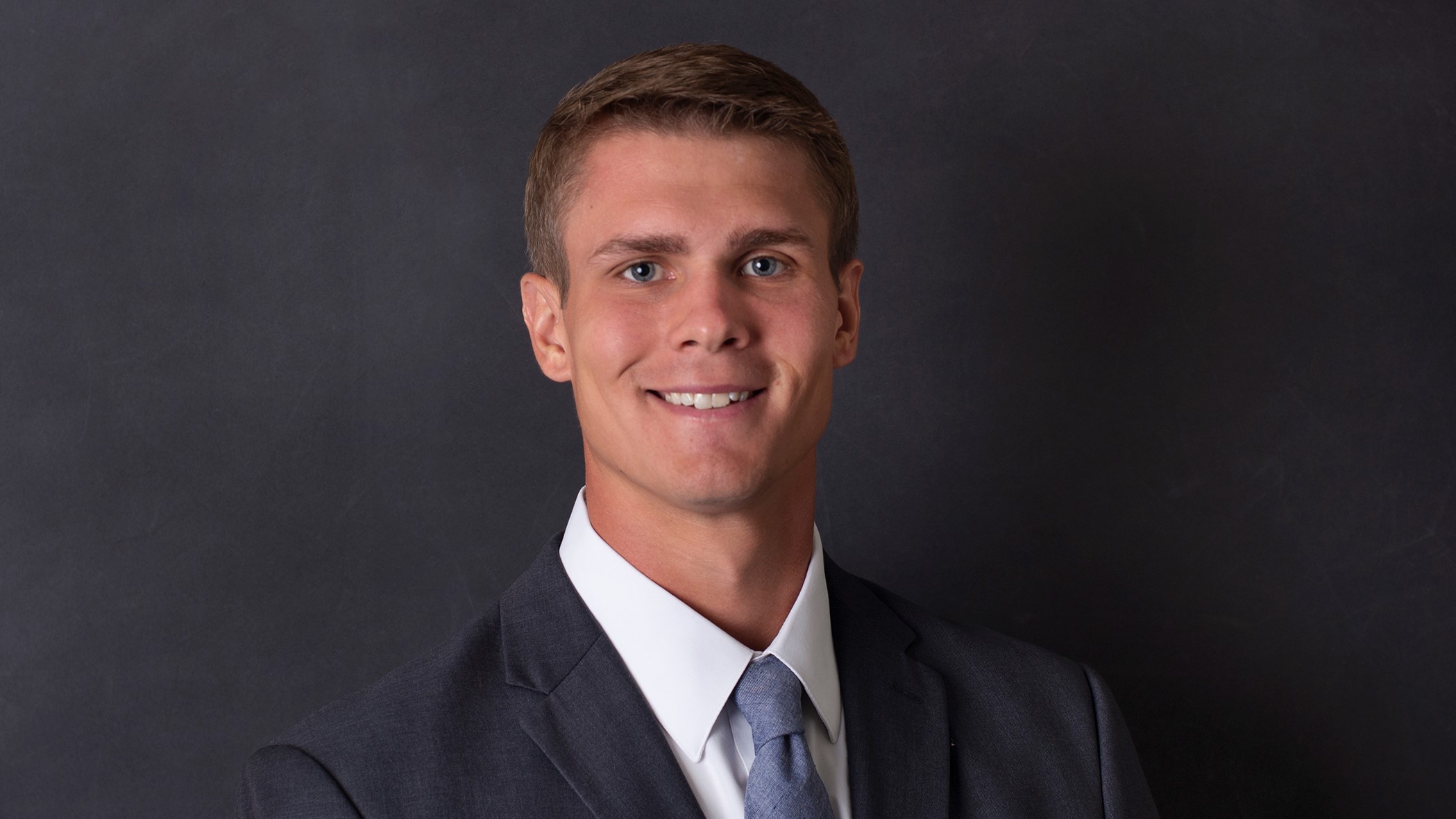 Clay Heitkamp, Marketing Representative at Celina Insurance Group, smiles in front of a black background.