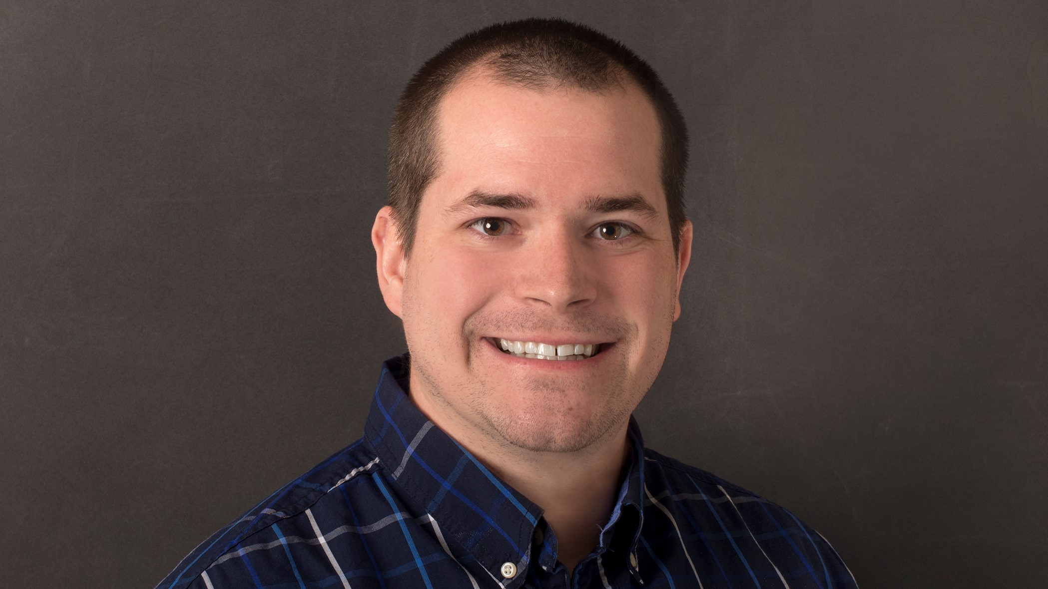 Richard Adams, Associate Commercial Lines Underwriter at Celina Insurance Group, smiles in front of a black background.