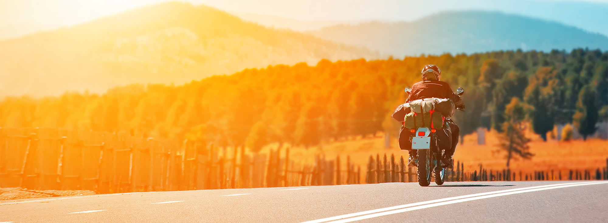 Motorcycle on an open road in a mountain setting.