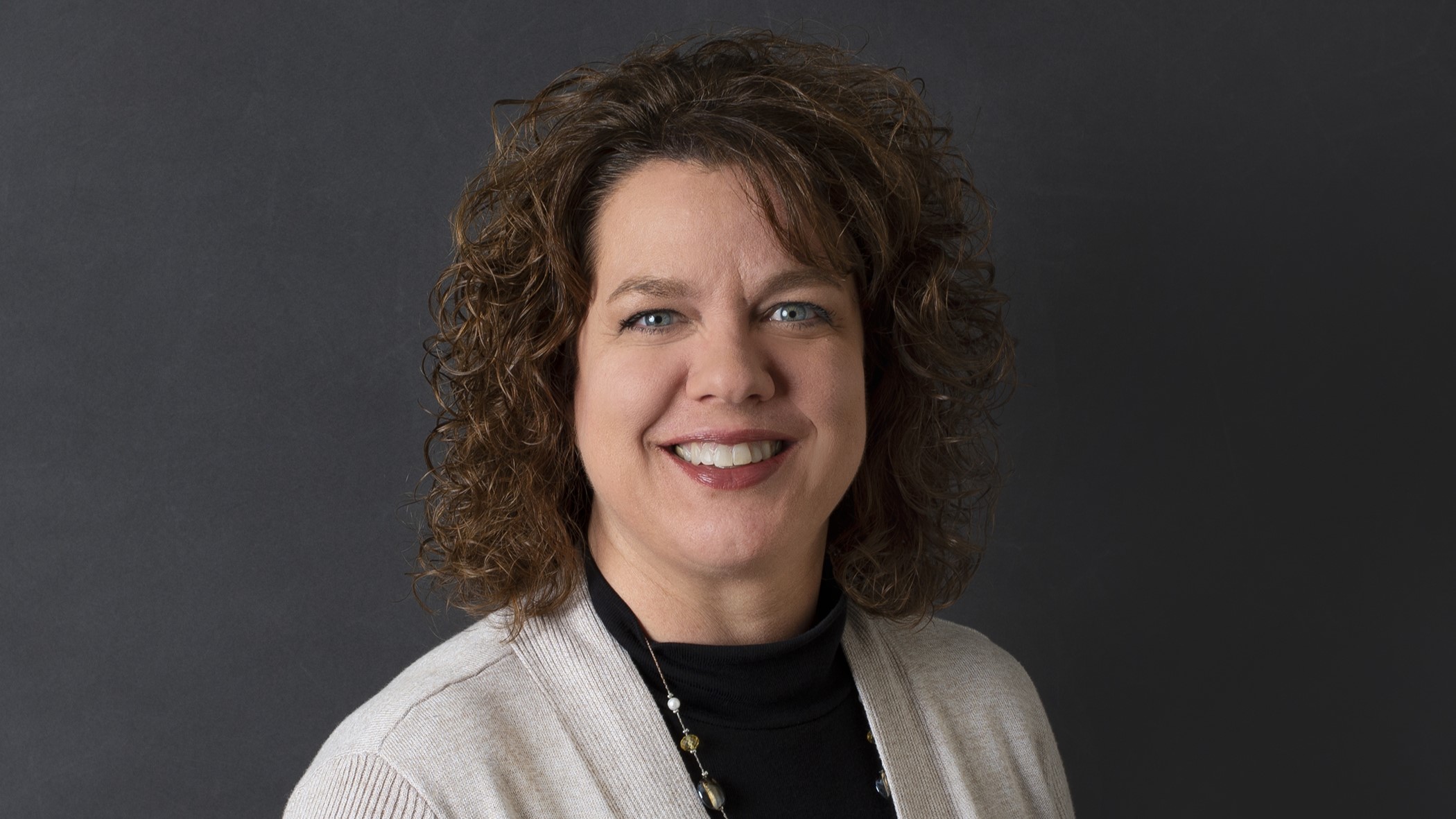 Karla Dieringer, Celina Insurance Group Commercial Lines Underwriting Manager, smiles in front of a black background.