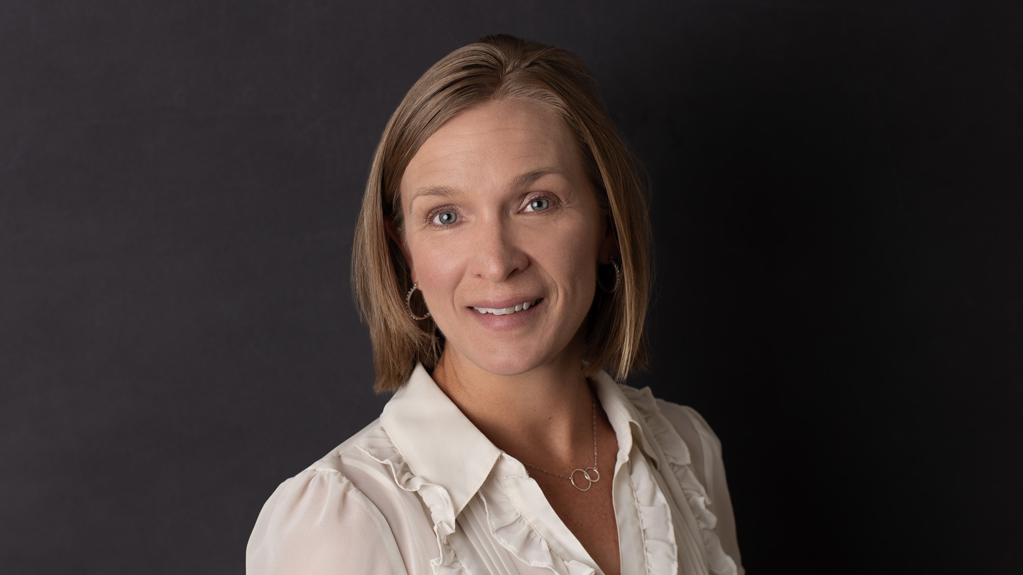 Danielle Schmackers, Celina Insurance Group Personal Lines Underwriting Manager, smiles in front of a black background.